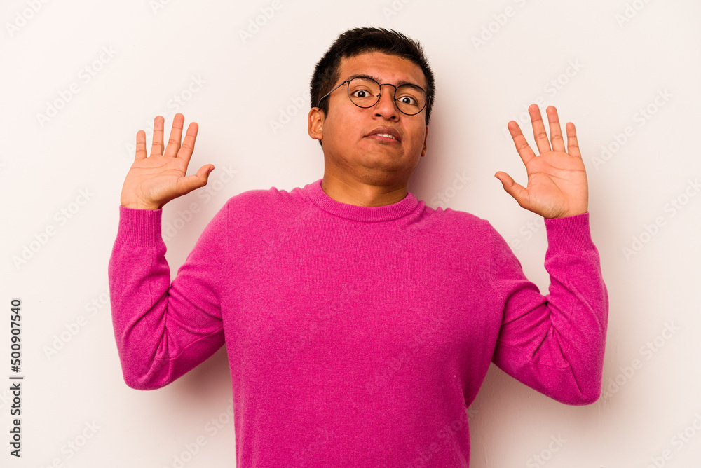Young hispanic man isolated on white background being shocked due to an imminent danger Young hispanic man isolated on white background being shocked due to an imminent danger