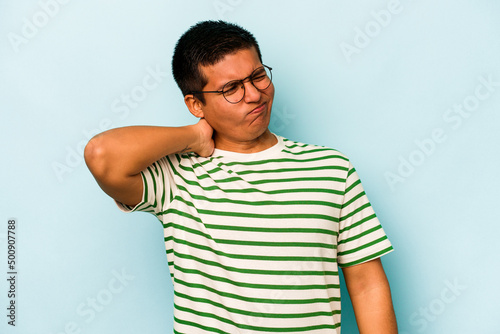 Young hispanic man isolated on blue background having a neck pain due to stress, massaging and touching it with hand.