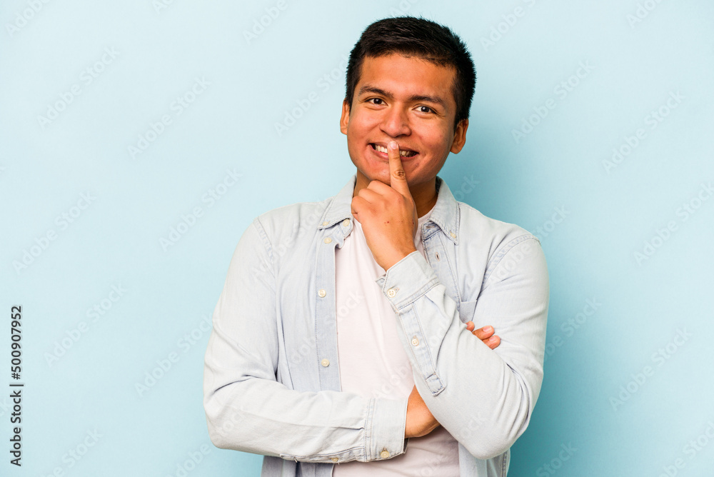 Young hispanic man isolated on blue background smiling happy and confident, touching chin with hand. Young hispanic man isolated on blue background smiling happy and confident, touching chin with hand.