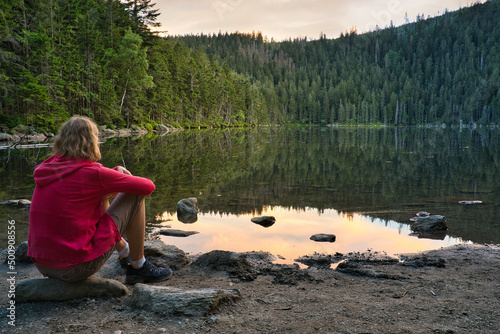 A woman sitting on the bank of beautiful Devil's Lake in the Bohemian Forest, Czech Republic © Susanne Fritzsche