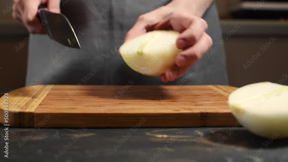 person slicing onion with a knife