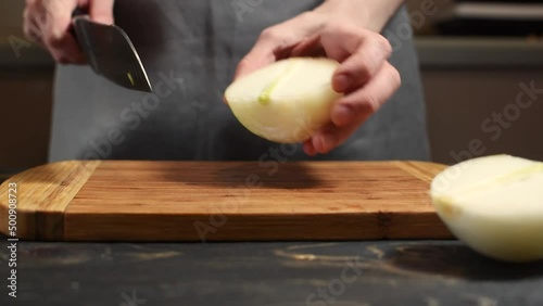 person slicing onion with a knife