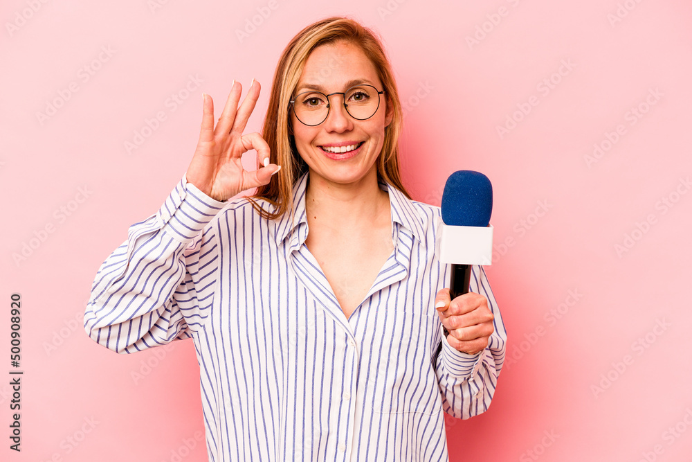 Young caucasian TV presenter woman isolated on pink background cheerful and confident showing ok gesture. Young caucasian TV presenter woman isolated on pink background cheerful and confident showing ok gesture.