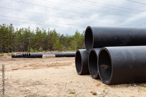 Laying of the pipeline. Large diameter pipe. A large plastic pipe. The pipe is black.