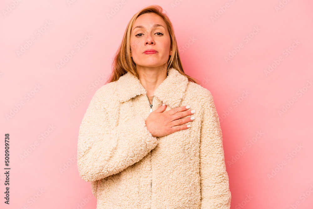 Young caucasian woman isolated on pink background taking an oath, putting hand on chest. Young caucasian woman isolated on pink background taking an oath, putting hand on chest.