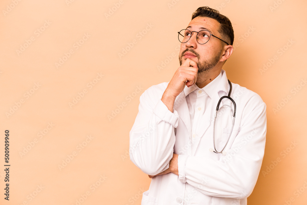 Hispanic doctor man isolated on beige background looking sideways with doubtful and skeptical expression. Hispanic doctor man isolated on beige background looking sideways with doubtful and skeptical expression.