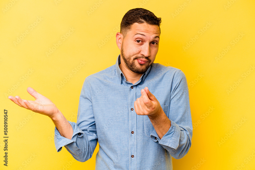 Young hispanic man isolated on yellow background showing that she has no money. Young hispanic man isolated on yellow background showing that she has no money.