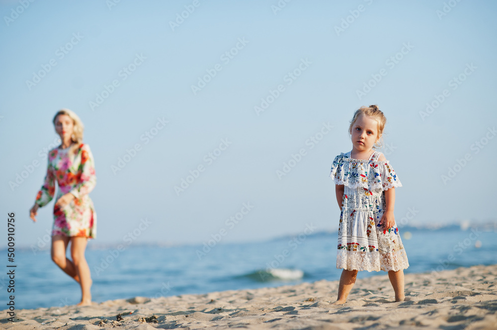 Mother and beautiful daughter having fun on the beach. Portrait of happy woman with cute little girl on vacation. Mother and beautiful daughter having fun on the beach. Portrait of happy woman with cute little girl on vacation.