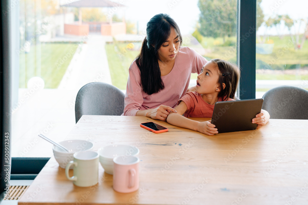 Asian woman and her daughter using tablet computer Asian woman and her daughter using tablet computer
