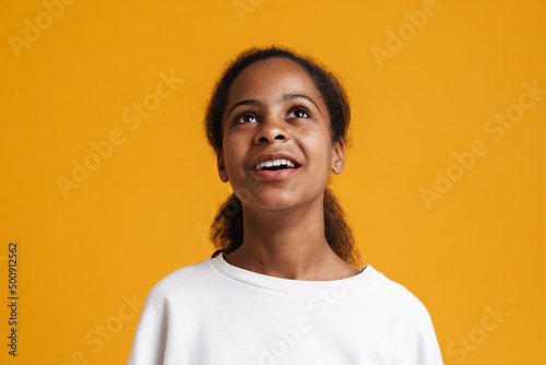 Brunette black girl wearing long-sleeve smiling and looking upward © Drobot Dean