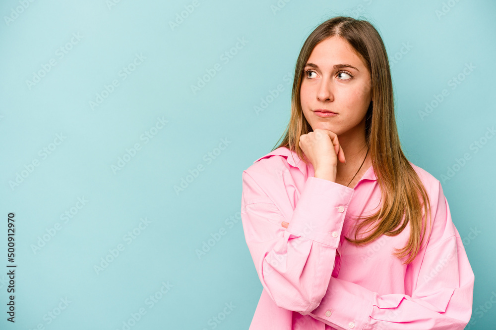 Young caucasian woman isolated on blue background looking sideways with doubtful and skeptical expression. Young caucasian woman isolated on blue background looking sideways with doubtful and skeptical expression.
