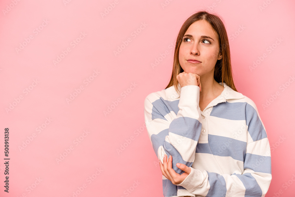 Young caucasian woman isolated on pink background looking sideways with doubtful and skeptical expression. Young caucasian woman isolated on pink background looking sideways with doubtful and skeptical expression.