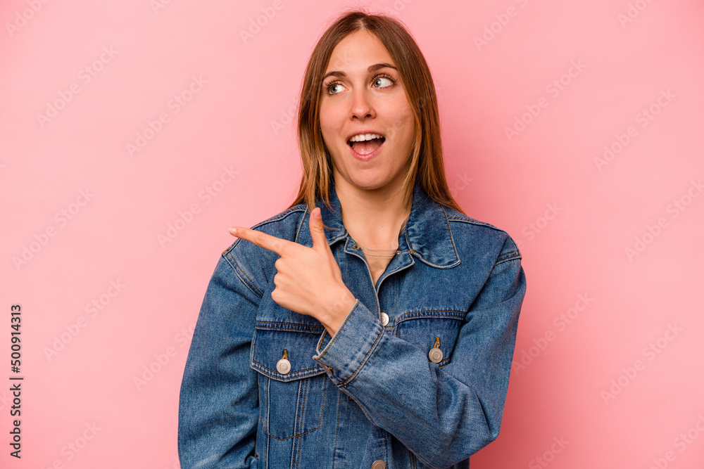 Young caucasian woman isolated on pink background looks aside smiling, cheerful and pleasant. Young caucasian woman isolated on pink background looks aside smiling, cheerful and pleasant.