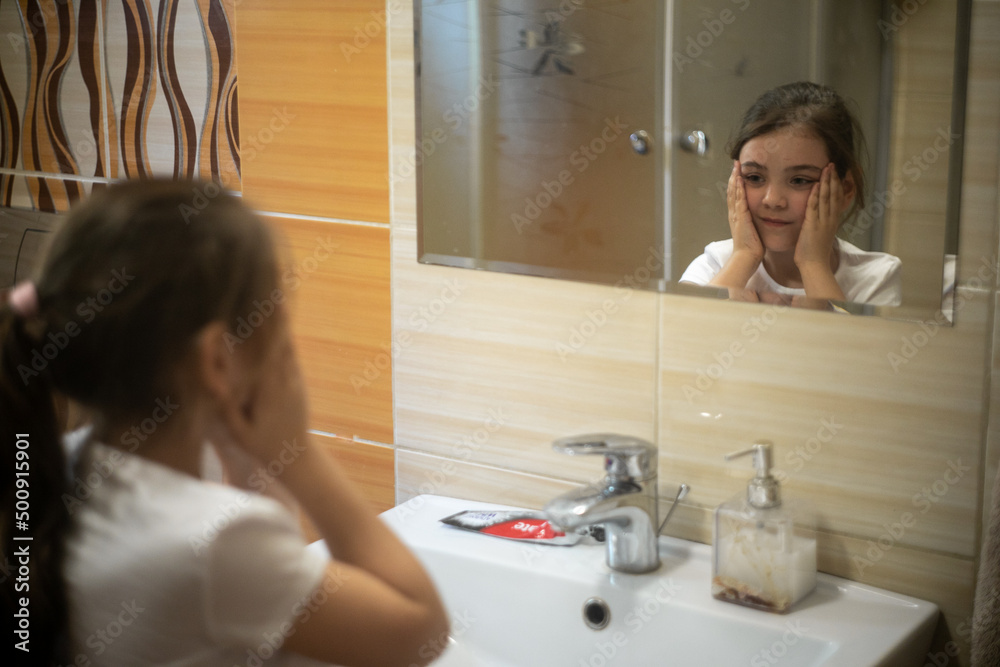 Dziewczynka myjąca twarz przed umywalką w łazience - obrazy, fototapety, plakaty 