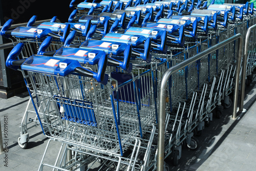 Many empty shopping carts near supermarket, closeup