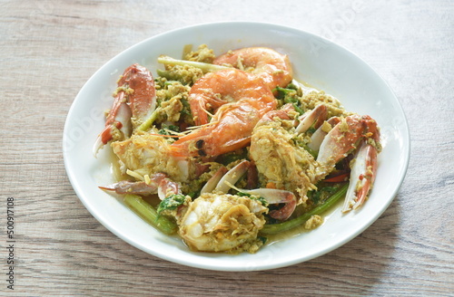 stir fried swimmer crab and shrimp in yellow curry with egg on plate