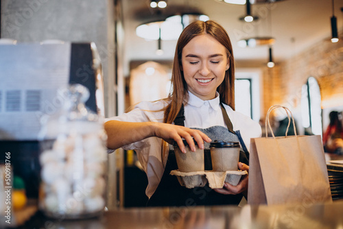 Slika na platnu Barista woman at coffee shop preparing coffee in cardboard cups
