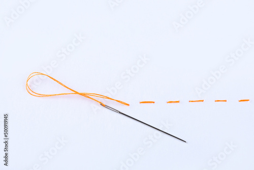 Yellow embroidery and needle on white background photo