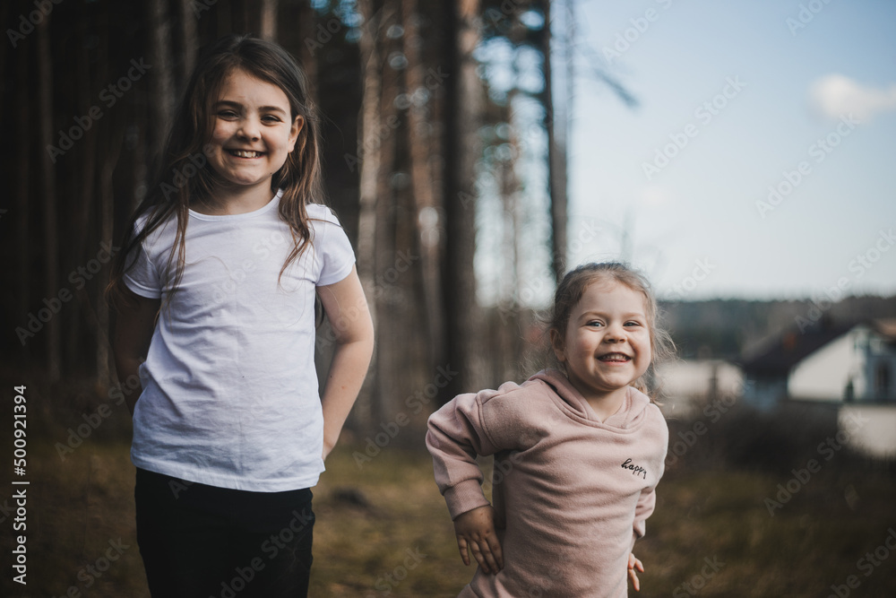 Dwójka dzieci w lesie pozuje do aparatu - obrazy, fototapety, plakaty 