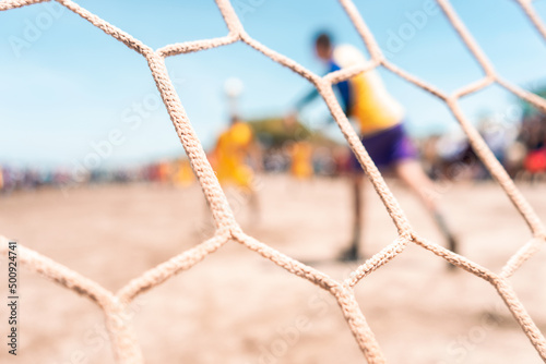 Unrecognizable goalkeeper throwing the ball during a soccer game on a beach in Masachapa, Nicaragua. Concept of popular sports in Latin America.