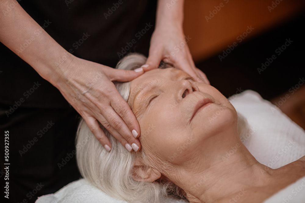A senior woman having a face massage in a beauty salon