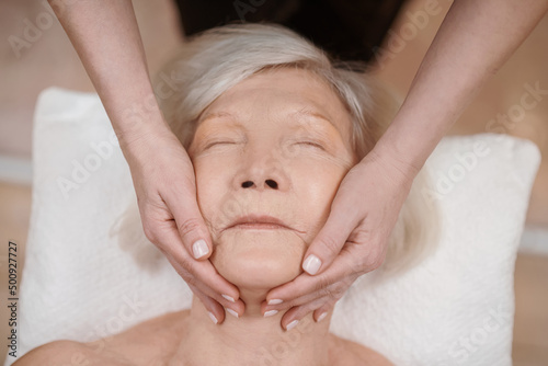 A senior woman having an anti-age massage in a beauty salon