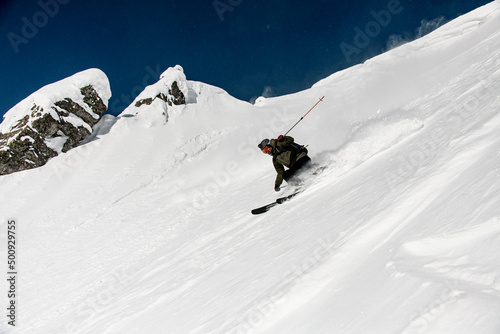 great view on male skier slides down the snow-covered slope. Freeride skiing concept