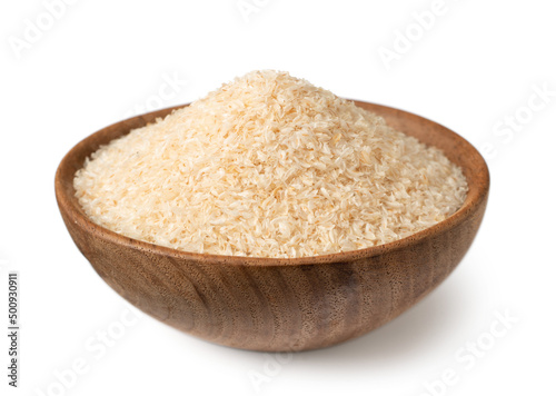 Psyllium husks in the wooden bowl, isolated on white background.