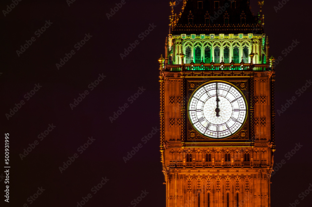 Big Ben of the Houses of Parliament London England UK at night striking midnight on new year's eve on Westminster Bridge which is a popular city landmark, stock photo with copy space - obrazy, fototapety, plakaty 