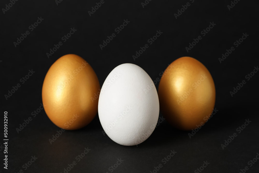 Golden and ordinary chicken eggs on black background Golden and ordinary chicken eggs on black background