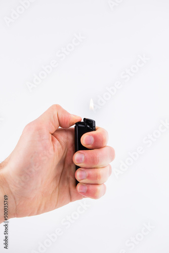 gas lighter in hand burns fire on a white background