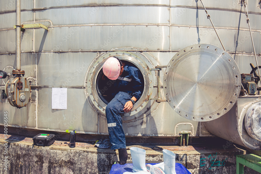Male worker into manhole fuel tank oil chemical protective clothing