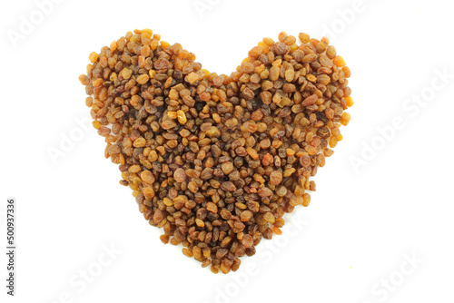 Dry grape raisins in heart shape form isolated on white background