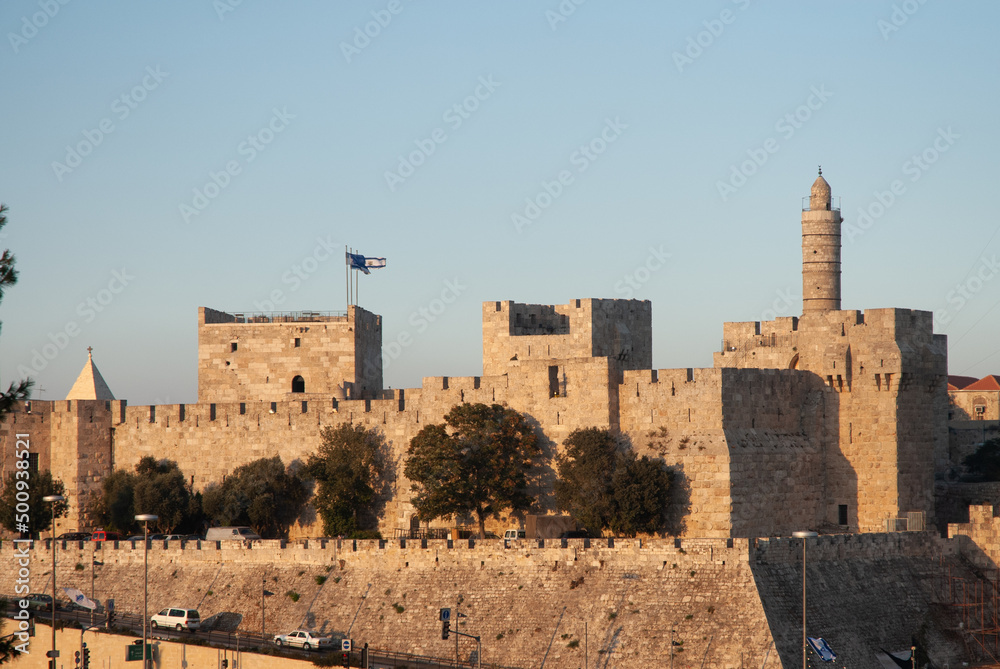 Afternoon view of the landmark, stone Tower of David minaret as golden sunlight strikes the ancient walls of the Old City of Jerusalem.