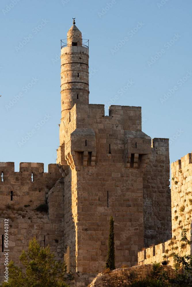View of the landmark, stone Tower of David and the surrounding walls and greenery of the Old City of Jerusalem.