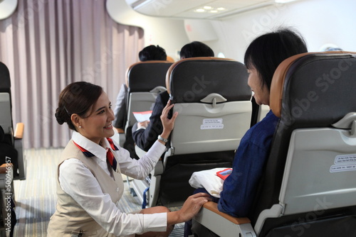 Fototapeta air hostess service on plane , flight attendant checking and closing cabin compa