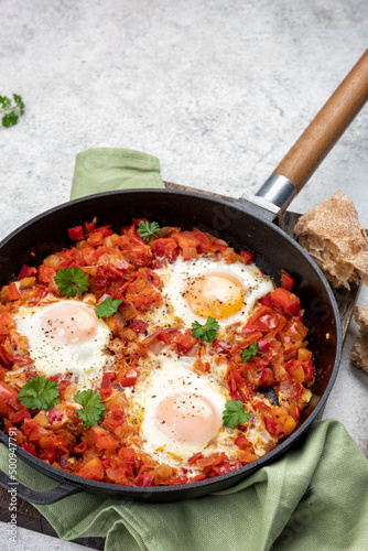 Shakshouka, eggs poached in sauce of tomatoes,