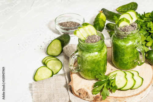 Green smoothie with cucumber in a glass jar. Fresh ripe vegetables, greens, and chia seeds