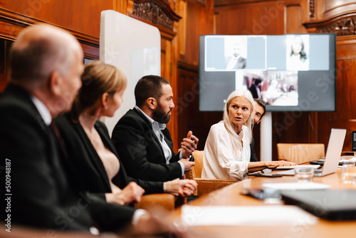 Female financial expert discussing with colleagues in meeting at board room photo