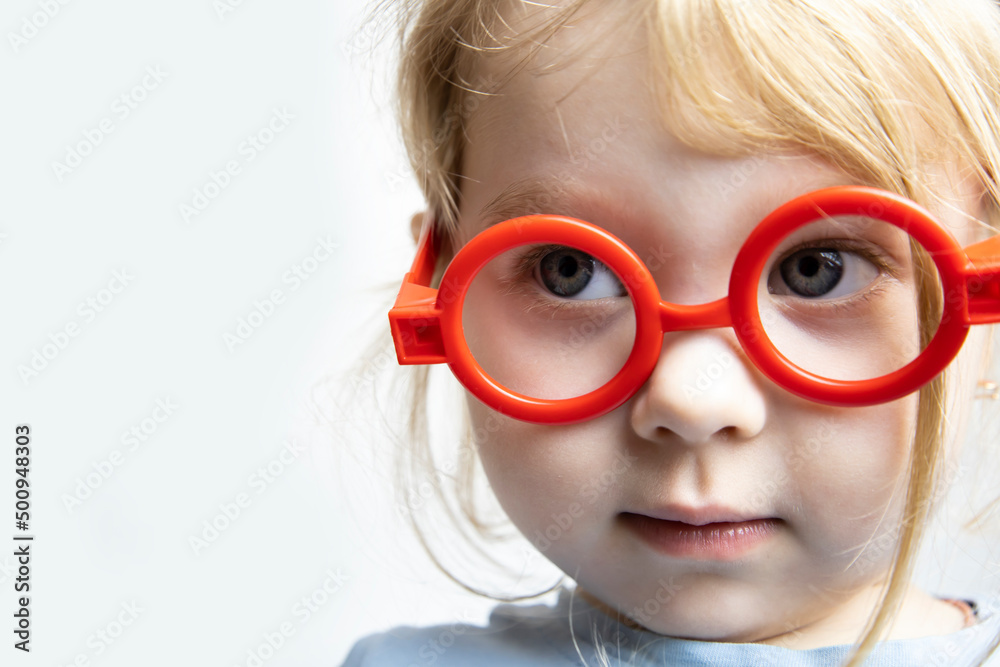 A three-year-old girl in baby glasses plays doctor. A three-year-old girl in baby glasses plays doctor.