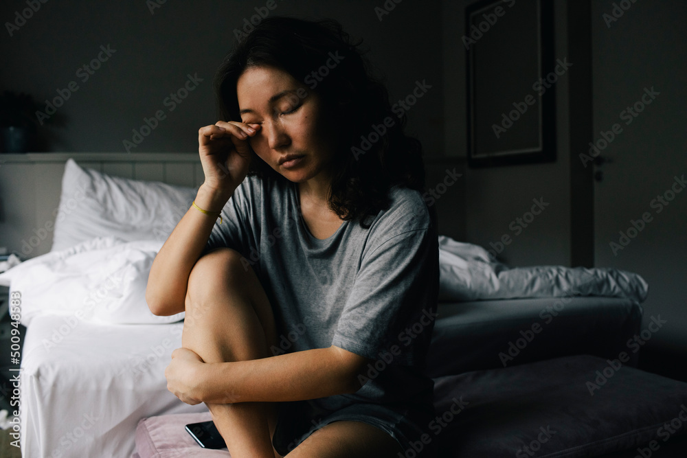 Mentally ill woman crying alone in bedroom at home Mentally ill woman crying alone in bedroom at home