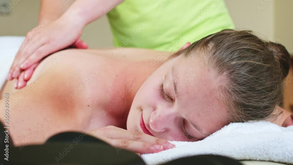 masseuse massages a woman back with öl masseuse massages a woman back with öl