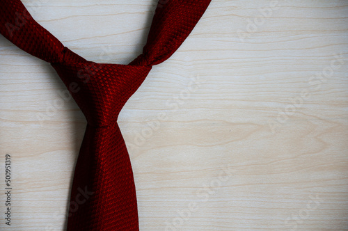 Red necktie on wooden background. Copy space concept