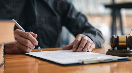 Lawyer man holding pen with contract or agreement document to the customer for signing in courtroom legal, Sign a contract business.