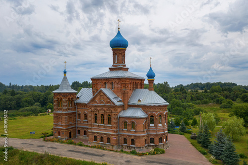 View of Church of St. Nicholas and St. George (Nikolo-Georgievskaya, 1894, Russian style) on cloudy summer day. Smogiri village, Smolensk Oblast, Russia. photo