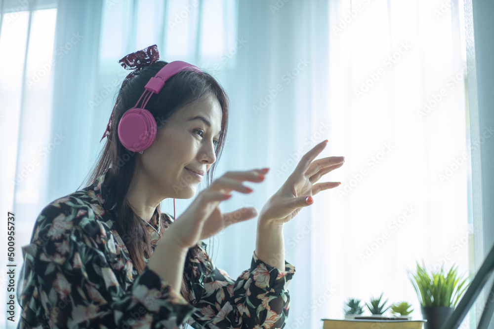 Fototapeta premium Asian woman having video call via computer in the home office.