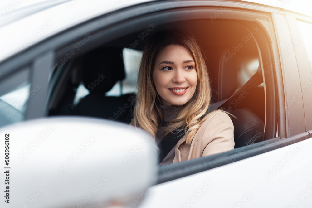 Young beautiful woman driver sitting in car, driving