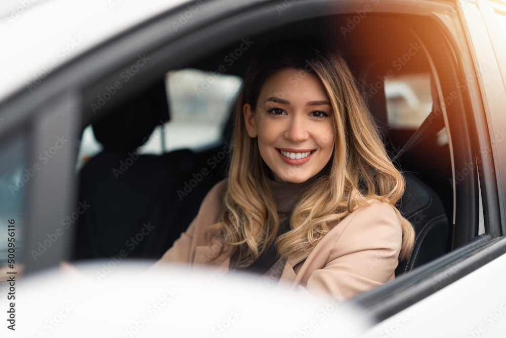 Young beautiful woman driver sitting in car, driving