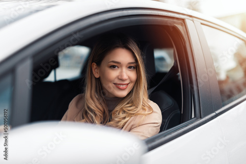 Young beautiful woman driver sitting in car, driving