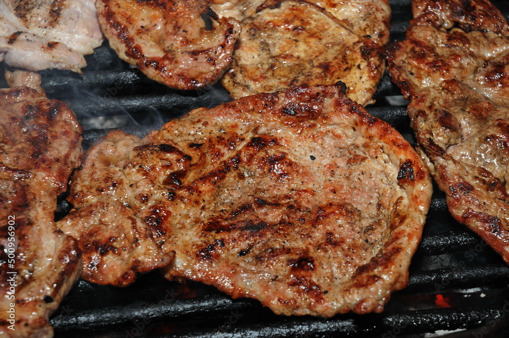 pork steak meat on bbq grill pan and potatoes, home made